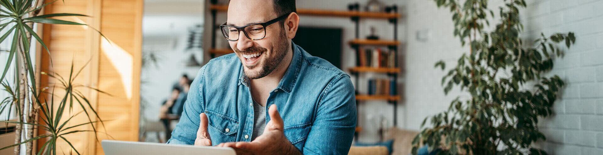 smiling man looking at his laptop