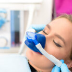 Woman relaxes at the dentist with a nose mask giving her nitrous oxide