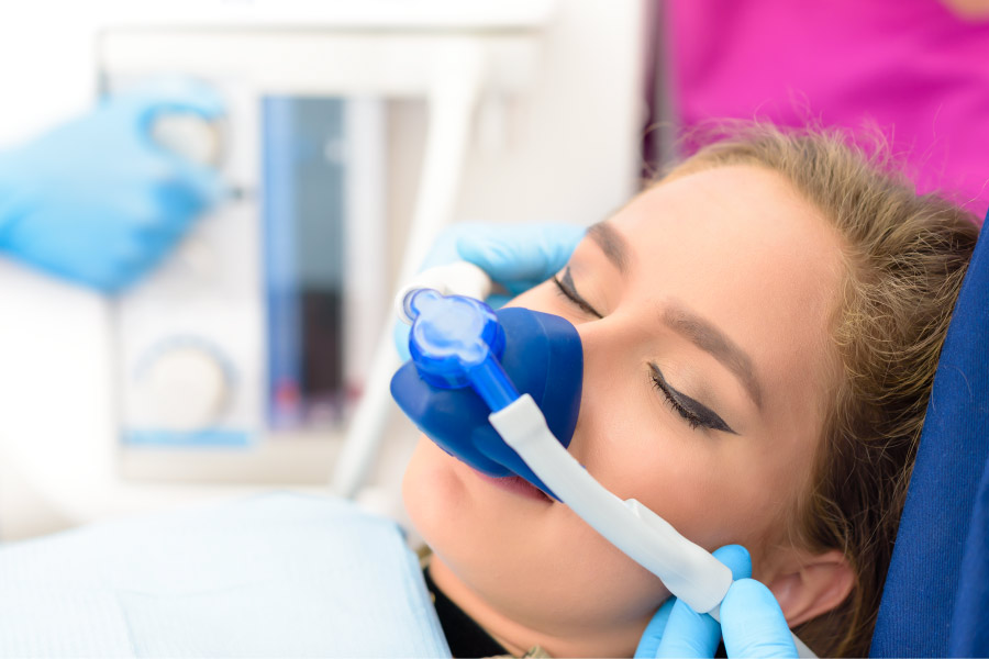 Woman relaxes at the dentist with a nose mask giving her nitrous oxide