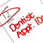 A calendar shows a patient has a dentist appointment in red ink at the dentist in Broken Arrow, OK