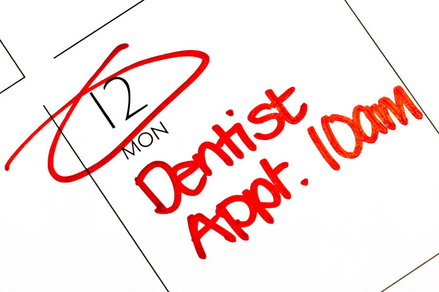 A calendar shows a patient has a dentist appointment in red ink at the dentist in Broken Arrow, OK