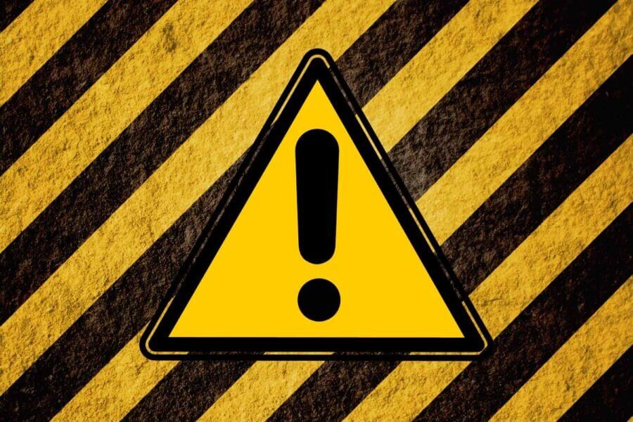 Yellow warning sign on black and yellow stripes to indicate caution