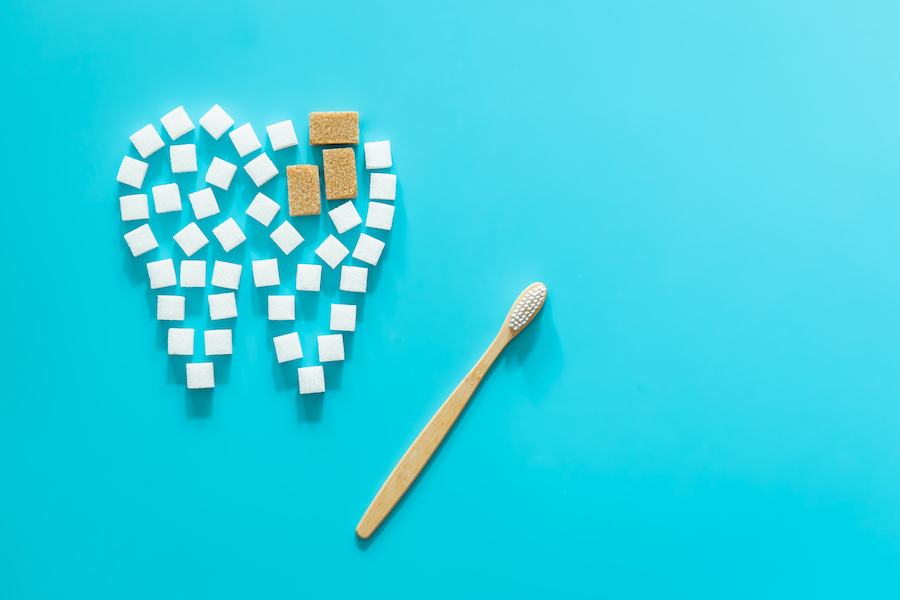 image of sugar cubes forming the shape of a tooth with cavities, dental plaque