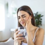 woman with sensitive teeth after drinking cold water