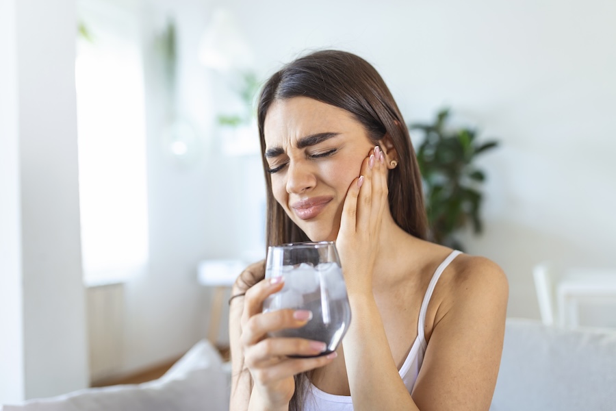 woman with sensitive teeth after drinking cold water