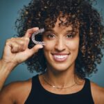 woman holding invisalign clear aligners after invisalign consultation